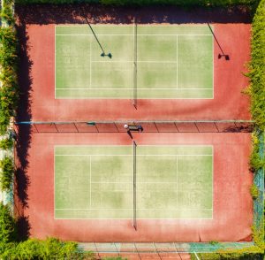 Aerial view of tennis court at sunset in summer. Top view