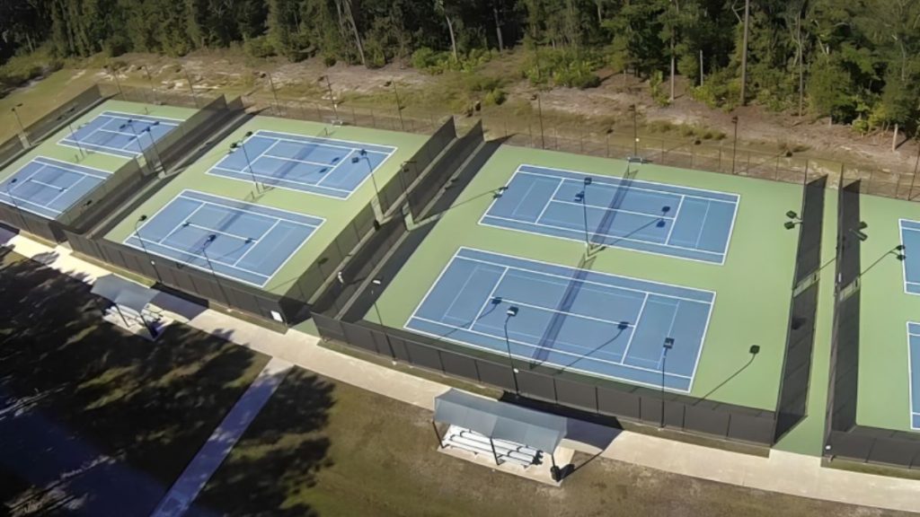 A Tennis Courts With Trees In The Background
