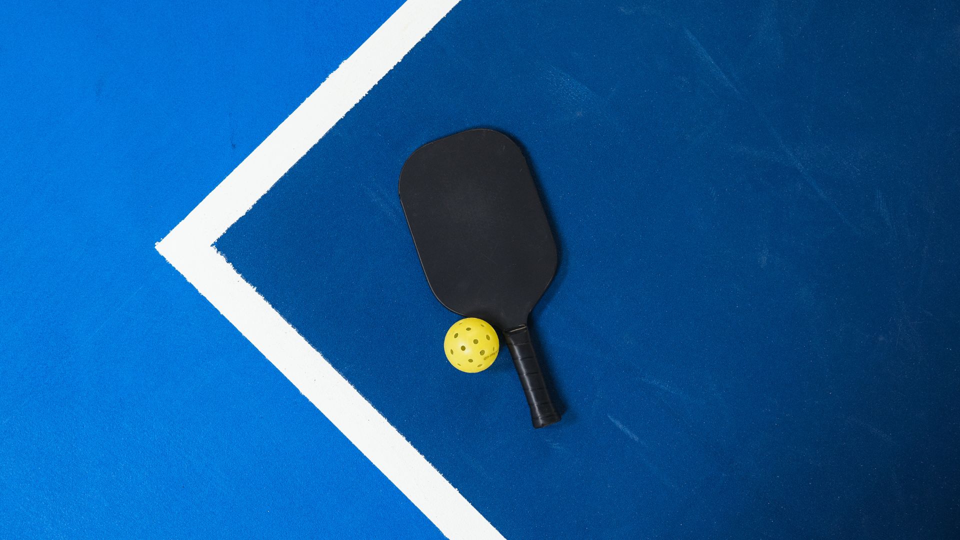Pickleball Paddle And Ball On Court